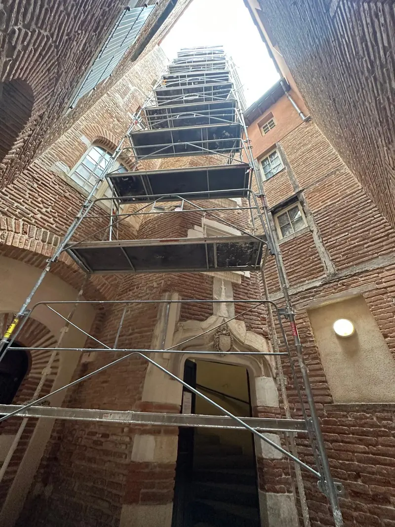 Échafaudage monté dans une cour intérieure de bâtiment ancien en brique